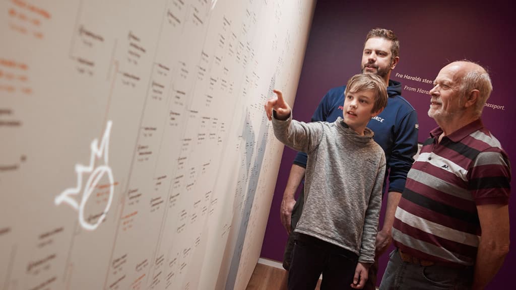 Vater, Großvater und Sohn sehen sich eine Übersicht über das dänische Königshaus an