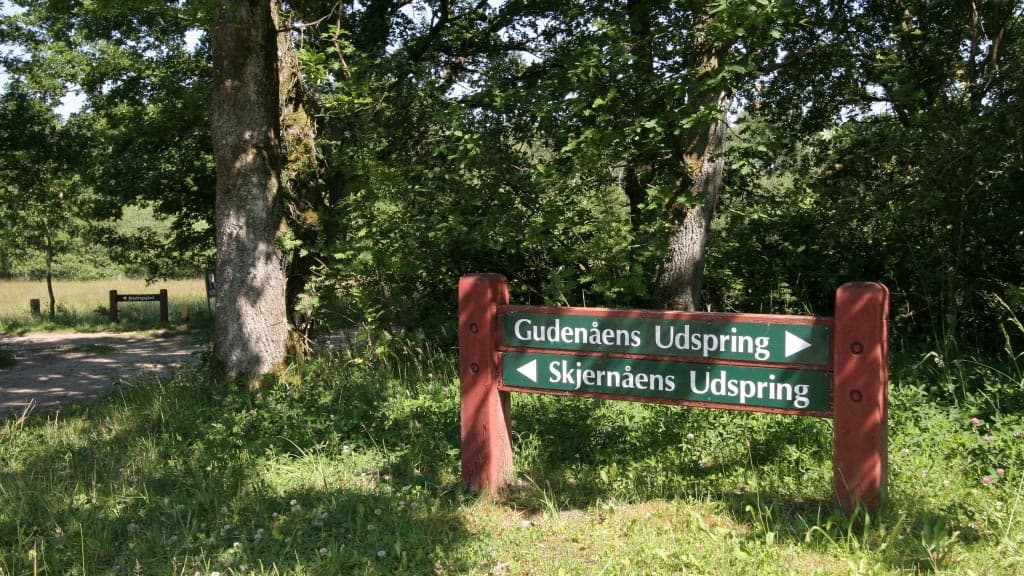 Sign at the Great Watershed points the way to the source of the Gudenå River and the Skjernå River