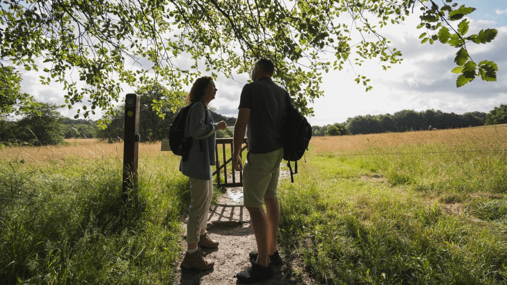 A couple is standing in front of a gate in Tinnet Krat on the Gudenå Trail