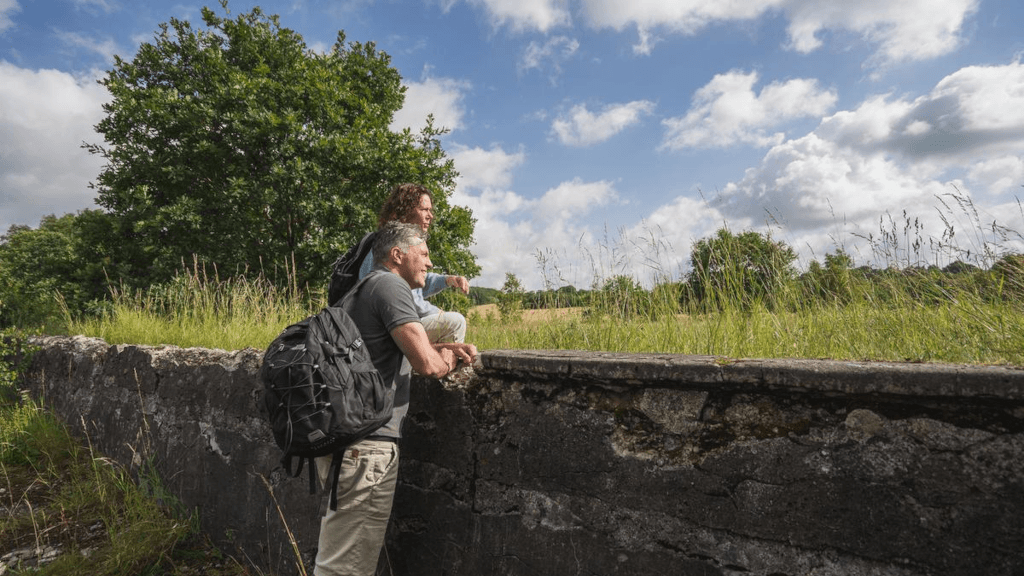 A couple is standing by the remains of an old water park in Tinnet Krat